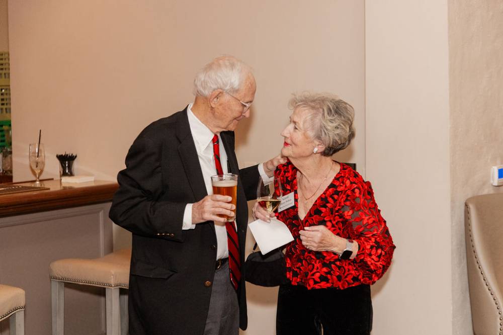Two holiday reception guests looking at each otherWoma